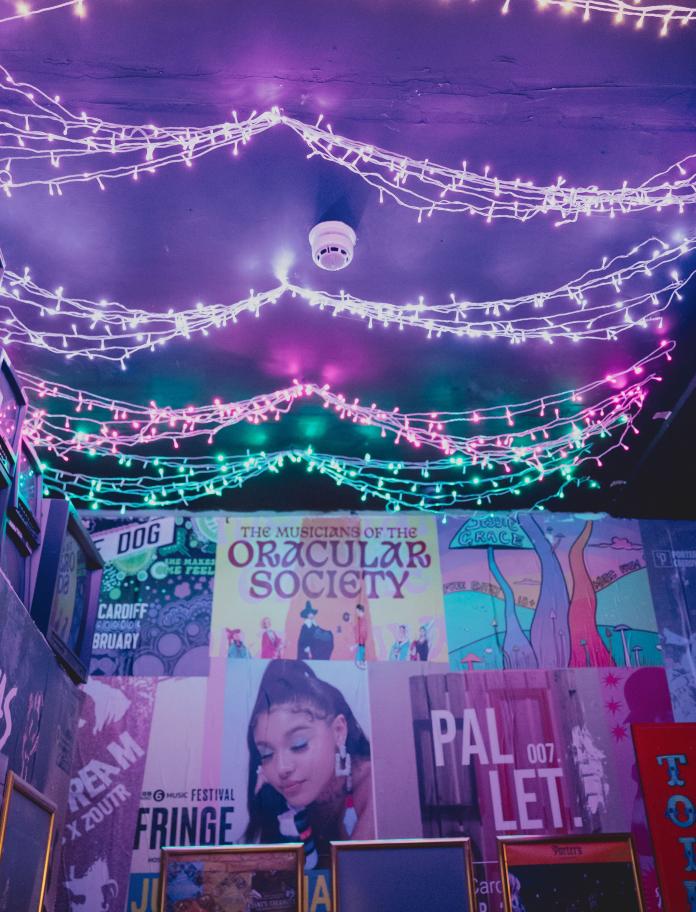 atmospheric purple fairy lights inside Porter's showing music posters of various artists