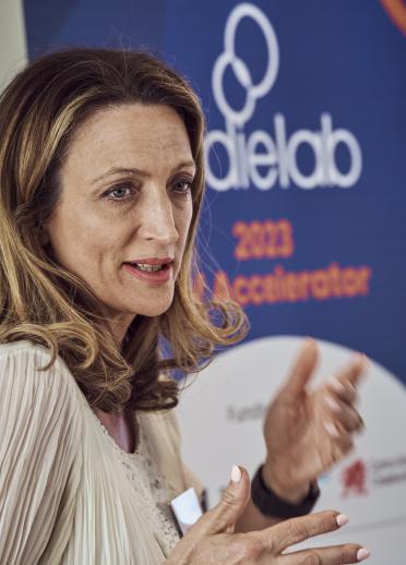 female gives presentation with an IndieLab pop up behind her