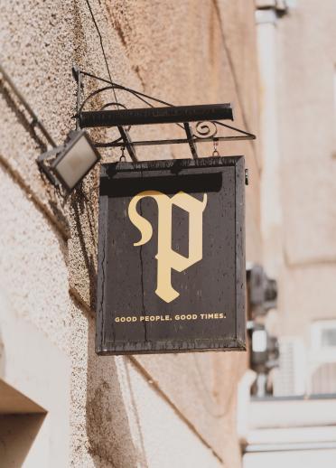 black sign with a gold P outside Porter's, Cardiff