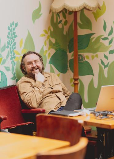 portrait of Dan looking relaxed on a chair at Porters