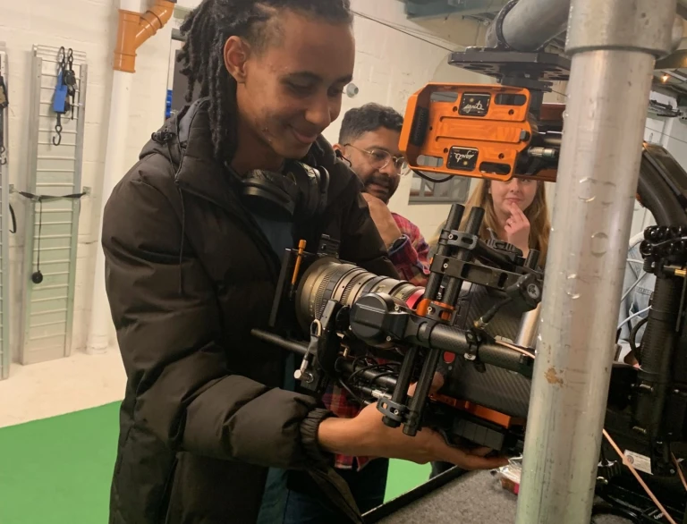 Person operating professional camera equipment in a workshop setting