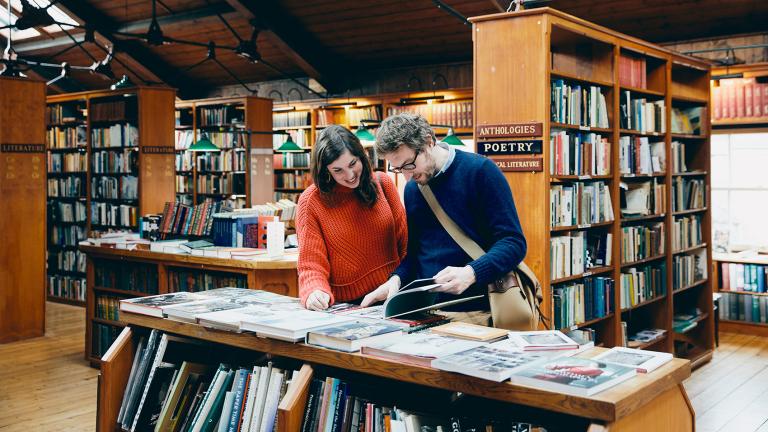 Two people looking at a book in a bookshop