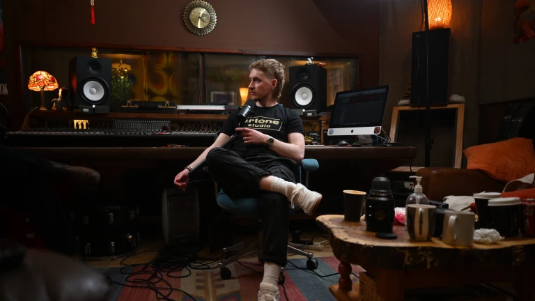 white man sits in recording studio with equipment in the background