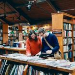 Two people looking at a book in a bookshop
