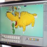 Computer screen with an artist drawing a yellow four-legged animal from Dr Seuss
