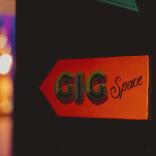 red sign with black writing saying 'GiG Space'