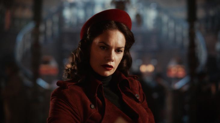 Portread o Mrs Coulter (Ruth Wilson) yn gwisgo cot goch a het goch yn His Dark Materials.